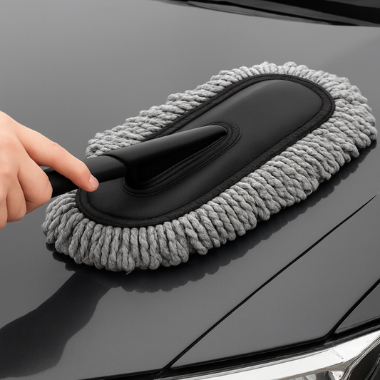 Drag-Auto Car cleaning brush with gray bristles being used on a car's black surface.