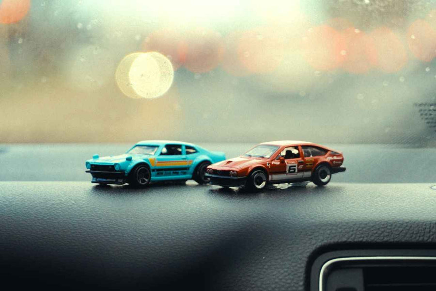 Featured Image DragAuto. Two miniature cars as models on dashboard 